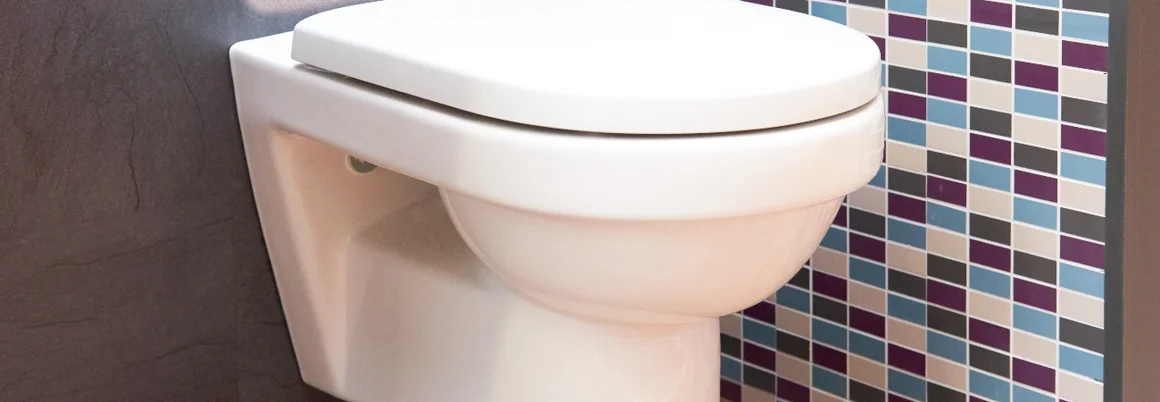 Hängende Toilette an gefliester Wand